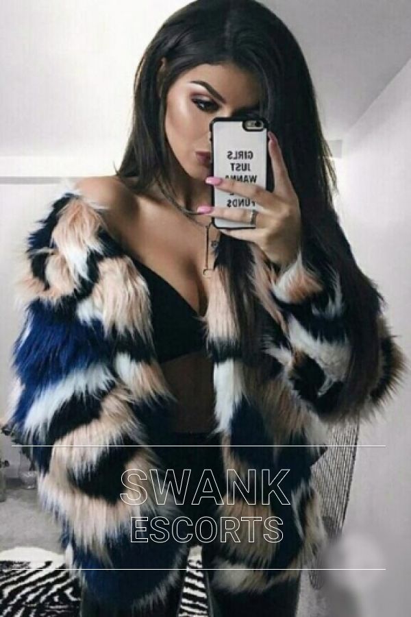 Cara wearing black and white coloured fur coat and black lingerie looking sexy taking mirror selfie 