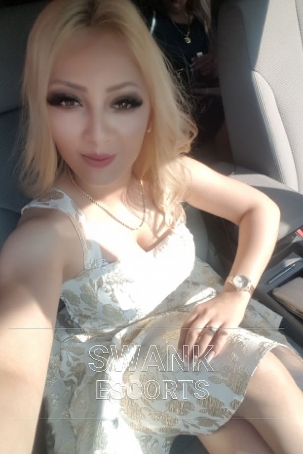 Maya taking a selfie in car wearing nice white dress